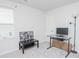 Bedroom with a window, white walls, carpet floors, and basic furnishings including a desk, chair, and small bench at 2121 Wildwind Dr, Graham, NC 27253