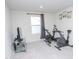 Bright exercise room featuring two exercise bikes, a glass console, and neutral walls with modern décor at 2121 Wildwind Dr, Graham, NC 27253