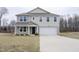 Charming two-story home featuring a well-manicured lawn, a two-car garage, and a welcoming front porch at 2121 Wildwind Dr, Graham, NC 27253