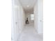 Bright hallway features white walls, carpet floors, recessed lighting, and a glimpse into a room with a TV and window at 2121 Wildwind Dr, Graham, NC 27253