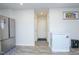 Open kitchen featuring stainless steel refrigerator and freezer, complemented by white walls and gray vinyl floors at 2121 Wildwind Dr, Graham, NC 27253