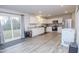 Bright kitchen with white cabinetry, stainless steel appliances, a sliding glass door, and gray wood-look flooring at 2121 Wildwind Dr, Graham, NC 27253