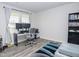 Office with wood-look floors, two windows, a modern desk setup, and a comfortable seating area at 2121 Wildwind Dr, Graham, NC 27253