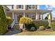 Inviting front porch with classic columns, an American flag, lush landscaping, and a welcoming entrance at 22 Old York Cir, Clayton, NC 27527