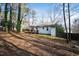 Large backyard with mature trees and a deck, offering a serene outdoor space at 224 Round About Rd, Holly Springs, NC 27540