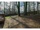 A view of a large backyard surrounded by a wooden fence and mature trees, perfect for outdoor activities at 224 Round About Rd, Holly Springs, NC 27540