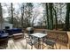 Outdoor deck featuring a grill, dining table, seating, and lush trees at 224 Round About Rd, Holly Springs, NC 27540