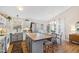 Open kitchen with white cabinets, an island with seating, and adjacent dining area at 224 Round About Rd, Holly Springs, NC 27540