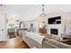 Open-concept living area featuring a modern fireplace, adjacent kitchen, and dining space for seamless entertaining at 224 Round About Rd, Holly Springs, NC 27540