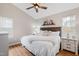 Bright main bedroom with a ceiling fan, plush bedding, and warm lighting at 224 Round About Rd, Holly Springs, NC 27540