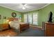 Comfortable bedroom features hardwood floors, a ceiling fan, and three bright windows at 241 Lifeson Way, Cary, NC 27519