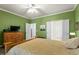 Cozy bedroom featuring a ceiling fan, wood floors, and multiple entry doors at 241 Lifeson Way, Cary, NC 27519