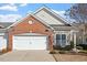 Charming home with a white garage door, brick and siding exterior and a well-maintained lawn at 241 Lifeson Way, Cary, NC 27519