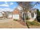 Beautiful curb appeal with brick accents, a white garage door and landscaped garden at 241 Lifeson Way, Cary, NC 27519