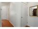 Hallway view with wood flooring, white walls, and framed mirror at 241 Lifeson Way, Cary, NC 27519