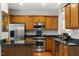 Well-appointed kitchen with wood cabinets, stainless steel appliances, and dark granite countertops at 241 Lifeson Way, Cary, NC 27519