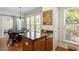 Bright kitchen with a dining area, featuring wood floors, granite countertops, and stainless steel appliances at 241 Lifeson Way, Cary, NC 27519