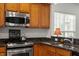 Well-appointed kitchen featuring stainless steel appliances, granite countertops, and custom wood cabinets at 241 Lifeson Way, Cary, NC 27519