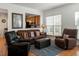 Comfortable living room featuring a leather sofa, recliner, and stylish decor with a view to the kitchen at 241 Lifeson Way, Cary, NC 27519