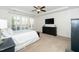 Bright bedroom features a ceiling fan, large window with plantation shutters, and dark wood dresser with a TV at 2436 Fiddich Ln, Fuquay Varina, NC 27526