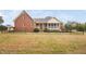 Brick home with a spacious lawn, a charming porch, and a secure fence at 4017 Olde Waverly Way, Fuquay Varina, NC 27526