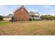 Backyard of a brick home with a porch, fence, and well-maintained lawn at 4017 Olde Waverly Way, Fuquay Varina, NC 27526