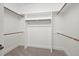 Walk-in closet features built-in shelving, rod racks, and neutral carpeting at 4017 Olde Waverly Way, Fuquay Varina, NC 27526