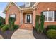 Welcoming brick front entrance with decorative glass door, manicured bushes and iron railings at 4017 Olde Waverly Way, Fuquay Varina, NC 27526