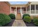 Inviting front porch with stone steps, a wooden walkway, and lush landscaping at 4017 Olde Waverly Way, Fuquay Varina, NC 27526