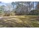 Expansive backyard featuring a mix of lush lawn and wooded areas, perfect for outdoor activities and privacy at 4307 Pope Rd, Durham, NC 27707