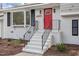 Close-up of the front entrance with a vibrant red door, white stairs, and modern black railings and shutters at 4307 Pope Rd, Durham, NC 27707