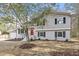 Charming two-story home featuring a bright red front door and a freshly landscaped yard with mature trees at 4307 Pope Rd, Durham, NC 27707