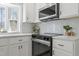 Modern kitchen featuring stainless steel appliances, stylish backsplash, and white cabinets at 4307 Pope Rd, Durham, NC 27707
