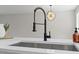 Close-up of a modern kitchen sink with a stylish faucet and ample counter space, perfect for meal preparation at 4307 Pope Rd, Durham, NC 27707