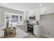 Modern kitchen with stainless steel appliances, white cabinets, and a window overlooking a lush yard at 4307 Pope Rd, Durham, NC 27707