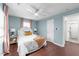 Bright bedroom features hardwood floors, ceiling fan, and view to the attached bathroom at 449 Parnell Dr, Raleigh, NC 27610