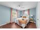 Bright bedroom features hardwood floors, ceiling fan, and a large window with natural light at 449 Parnell Dr, Raleigh, NC 27610