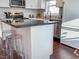 View of kitchen island with a black countertop, white cabinets, and seating for casual dining at 449 Parnell Dr, Raleigh, NC 27610