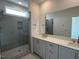 Bathroom featuring a glass shower, a window, and a double vanity with quartz counters at 526 Billingshurst Way # 211, Knightdale, NC 27545