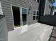This back patio features sliding glass doors, grey siding, and concrete flooring at 526 Billingshurst Way # 211, Knightdale, NC 27545