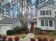 Inviting home exterior and garage with a red door, surrounded by lush landscaping and tall trees at 595 Weathersfield # A, Pittsboro, NC 27312
