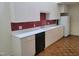 Kitchen featuring white cabinets, red tile backsplash, and stainless steel appliances at 595 Weathersfield # A, Pittsboro, NC 27312