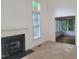 Bright living room boasts a fireplace, plush carpet, and view into sunroom at 595 Weathersfield # A, Pittsboro, NC 27312