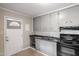 Functional kitchen with gray cabinets, tile floors, and white door at 617 Bernice St, Durham, NC 27703