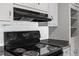 Kitchen area features black stove and overhead ventilation at 617 Bernice St, Durham, NC 27703