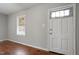 The front room of the house has hardwood flooring, a window, and a front door entrance at 617 Bernice St, Durham, NC 27703
