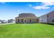 The backyard features green lawn with full view of the home's rear exterior at 625 Spellbrook Rd, Zebulon, NC 27597