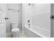 Clean bathroom featuring tub-shower, toilet, towel rack, and neutral floor tiles at 625 Spellbrook Rd, Zebulon, NC 27597