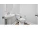 Half bathroom with pedestal sink, modern fixtures, and wood flooring at 625 Spellbrook Rd, Zebulon, NC 27597