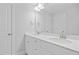 Bright bathroom featuring double sinks, white cabinets, quartz counters, and a large mirror at 625 Spellbrook Rd, Zebulon, NC 27597